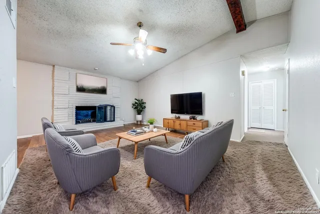 a living room with furniture a fireplace and a flat screen tv