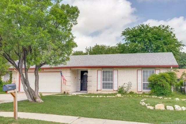 a front view of a house with a yard and trees