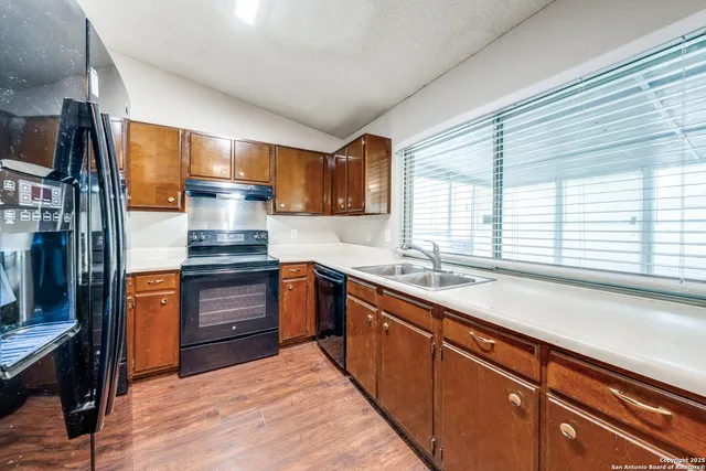 a kitchen with stainless steel appliances a sink stove and cabinets