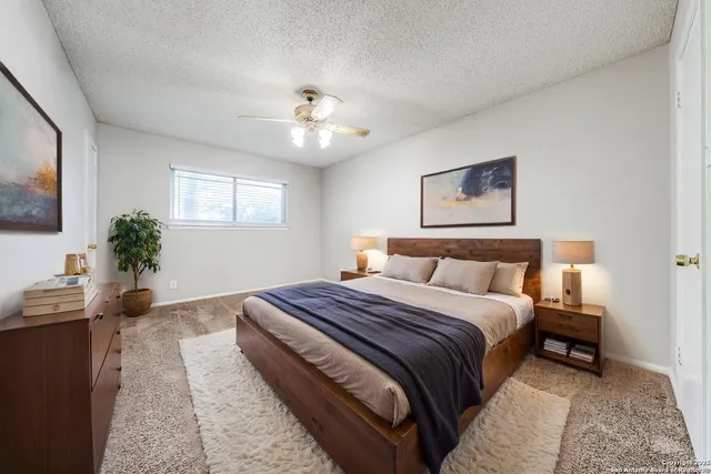 a bedroom with a large bed and a chandelier