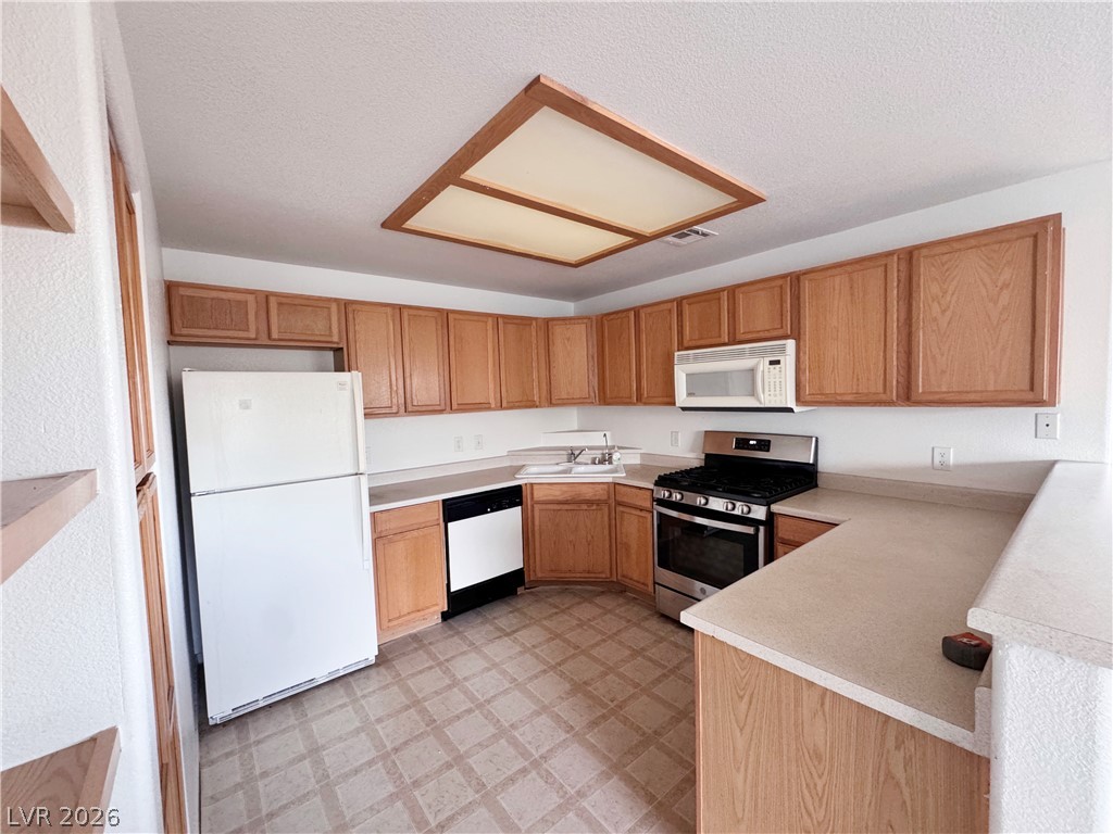 9580 West Reno Avenue, Unit 242 Las Vegas, NV 89148 - Photo 5 of 26 A well-appointed kitchen offers ample cabinetry and essential appliances for everyday culinary needs.