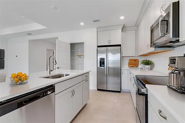 a kitchen that has a sink and stainless steel appliances