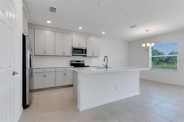 a kitchen with white cabinets and window
