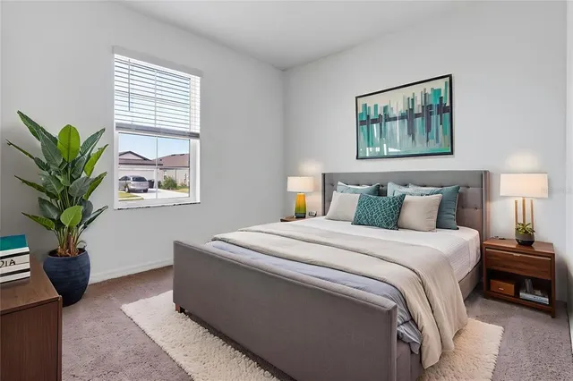 a bedroom with a bed and a potted plant