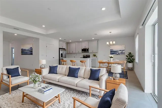 a living room with furniture white walls and a view of kitchen
