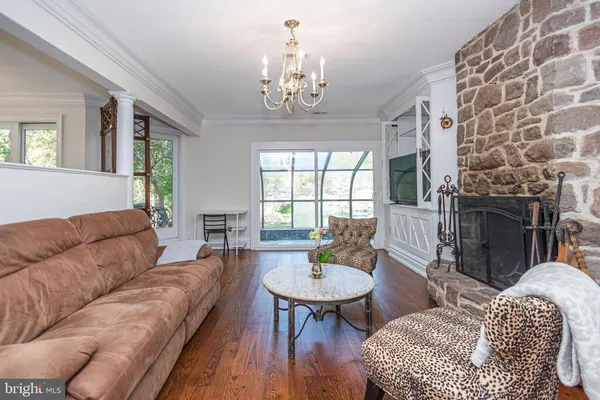 a living room with furniture a chandelier and a fireplace