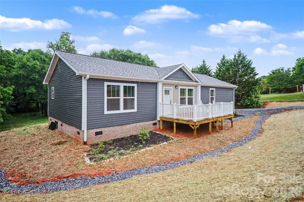 a view of a house with a yard and wooden fence