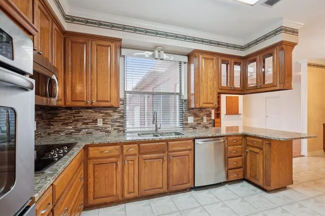 a kitchen with stainless steel appliances granite countertop a stove a sink and a refrigerator