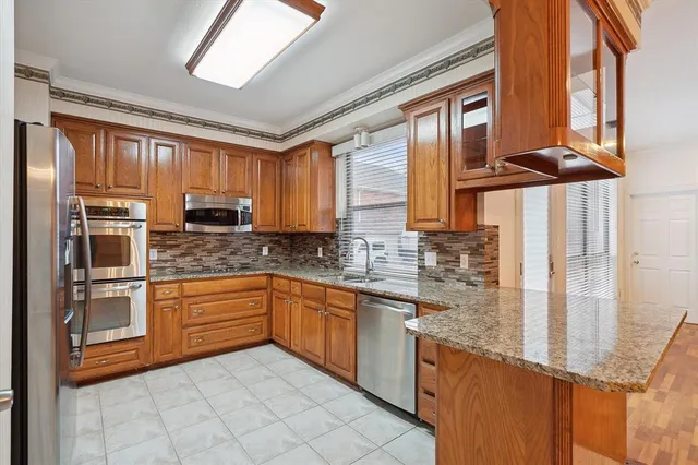 a kitchen with stainless steel appliances granite countertop a stove a sink and dishwasher