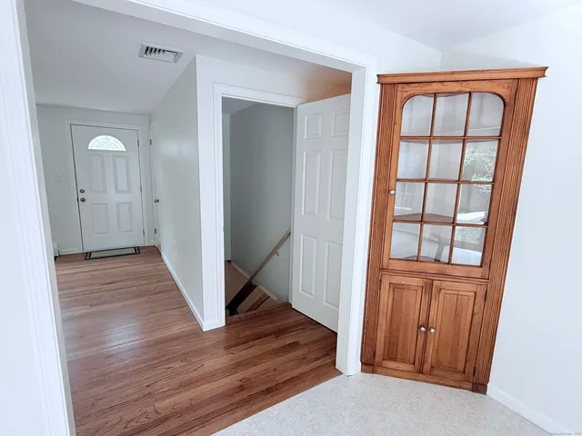 a view of a hallway with wooden floor and entryway