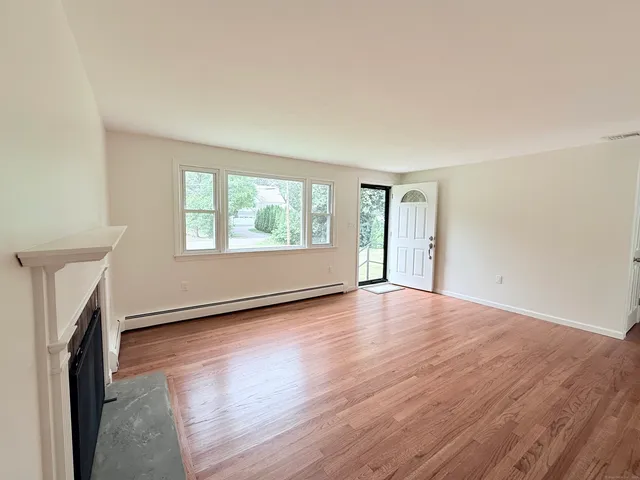 an empty room with wooden floor and a window