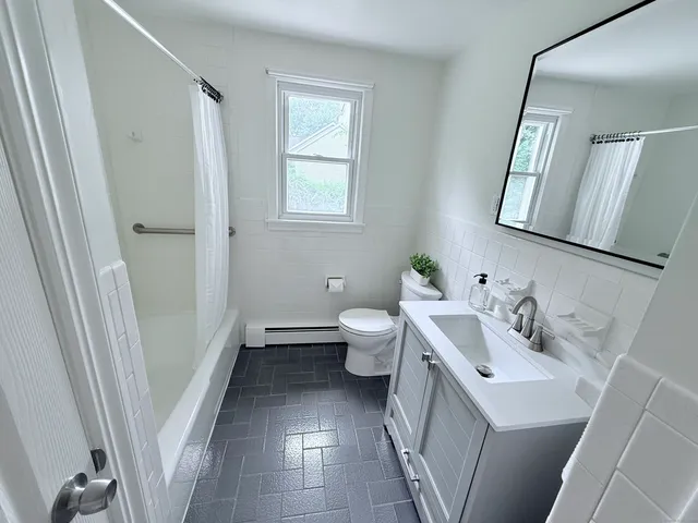 a bathroom with a sink a toilet and a mirror
