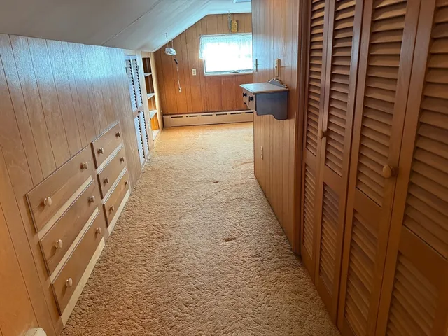 a view of a hallway to a livingroom with furniture and stairs