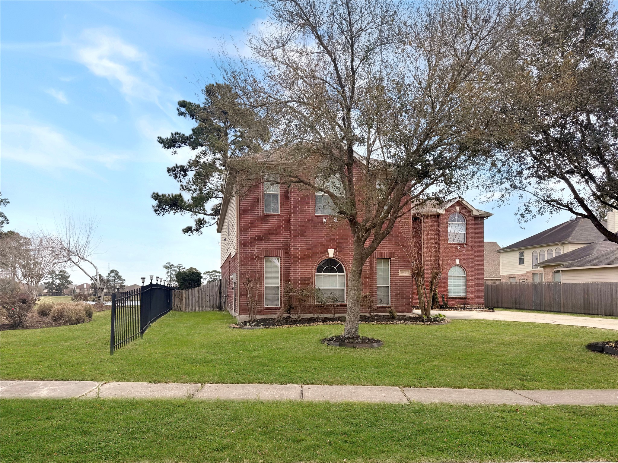 a view of a house with a big yard and large trees