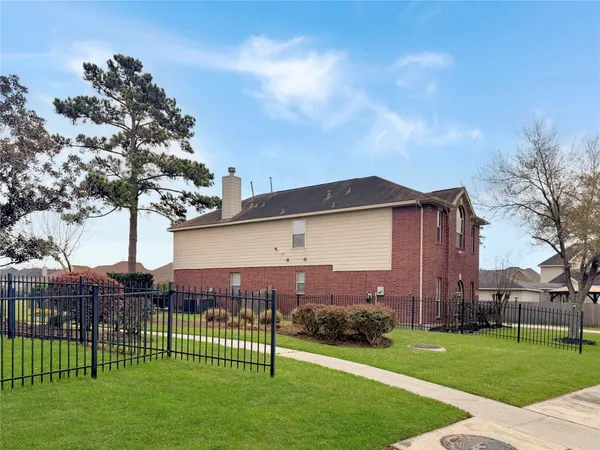 a view of a house with a big yard and large trees