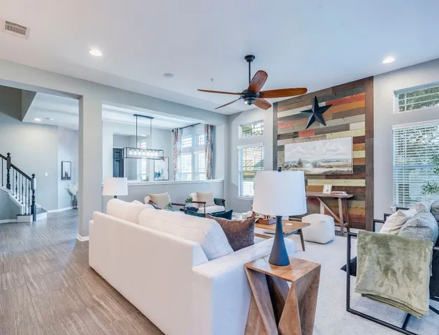 a living room with furniture a large window and a chandelier