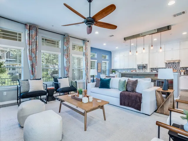 a living room with furniture a fireplace and a large window
