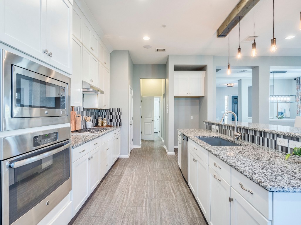 2930 Grand Oaks Loop, Unit 1903 Cedar Park, TX 78613 - Photo 9 of 36 a large kitchen with granite countertop a sink and cabinets