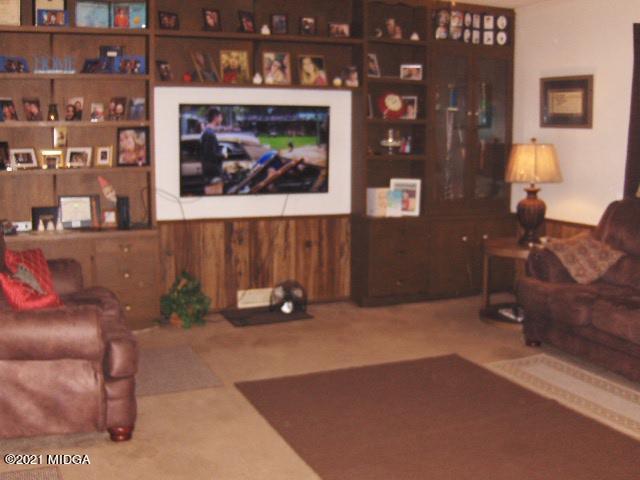 7152 Goodall Mill Road Macon, GA 31216 - Photo 10 of 25 a living room with furniture a bunch of shelves and a painting on the wall