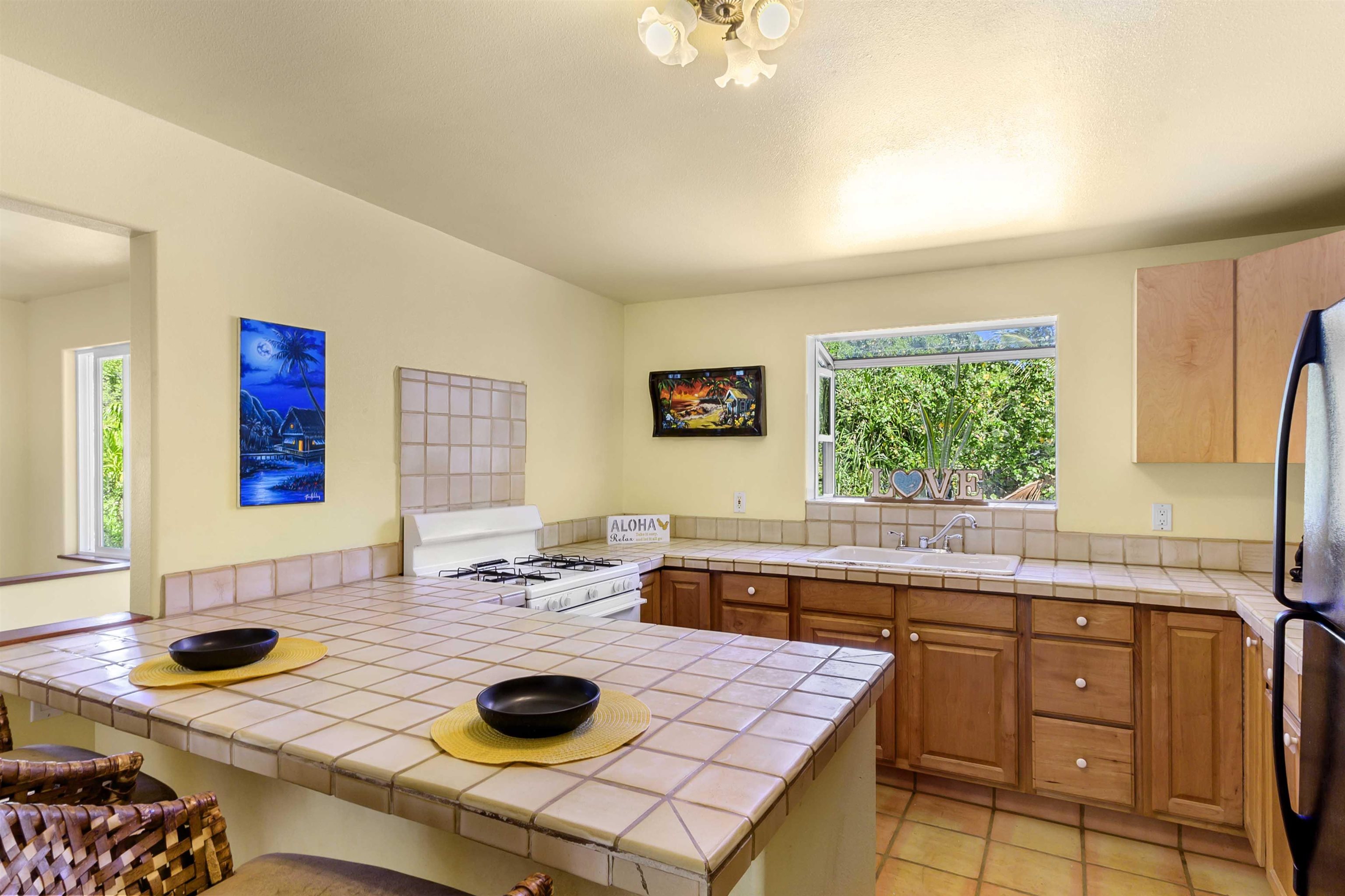 404 Puniawa Road Haiku, HI 96708 - Photo 10 of 36 a kitchen with a sink a stove a dining table and chairs