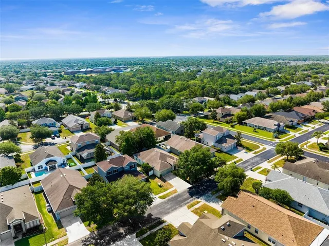 an aerial view of residential houses with outdoor space and ocean view