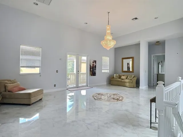 a living room with a black white checkered floor with a gaming machine and dining table