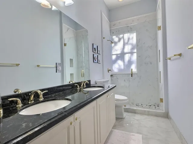 a bathroom with a toilet a sink and mirror