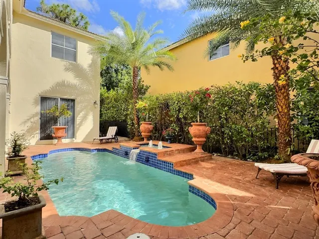 a view of a house with backyard and sitting area