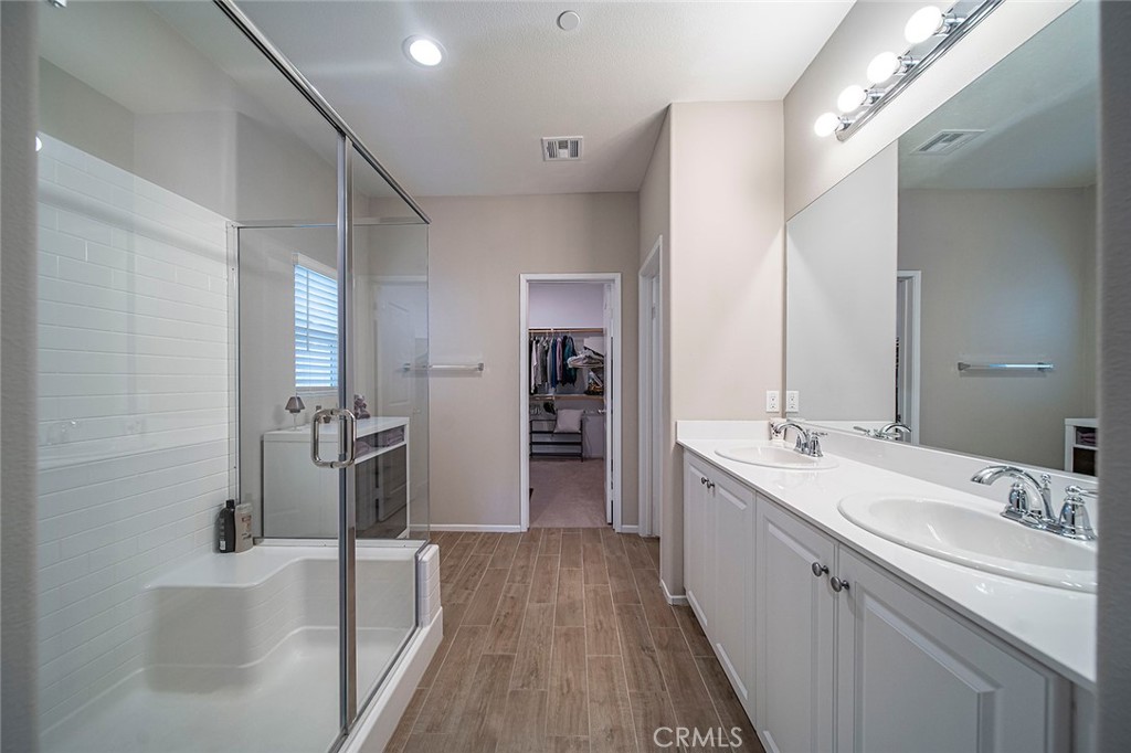 1189 Heritage Drive Calimesa, CA 92320 - Photo 13 of 36 a large bathroom with a double vanity sink a mirror and a shower