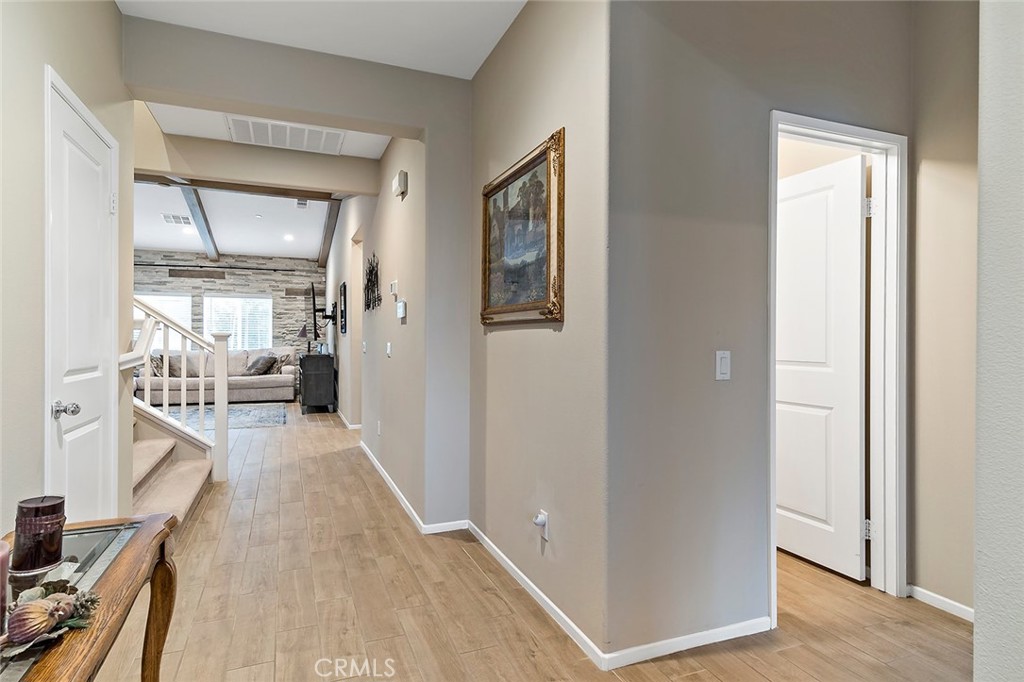 1189 Heritage Drive Calimesa, CA 92320 - Photo 16 of 36 a view of a hallway with wooden floor and livingroom