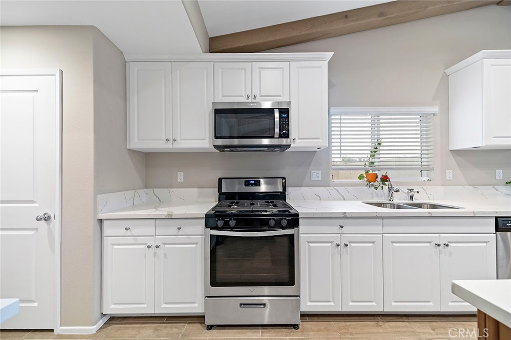 1189 Heritage Drive Calimesa, CA 92320 - Photo 7 of 36 a kitchen with white cabinets and appliances
