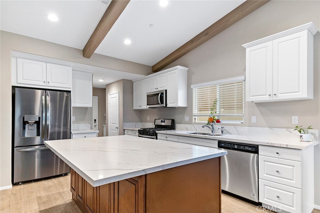 1189 Heritage Drive Calimesa, CA 92320 - Photo 9 of 36 a kitchen with stainless steel appliances a sink stove refrigerator and cabinets
