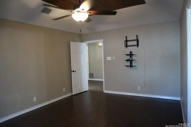 an empty room with a empty space and a ceiling fan