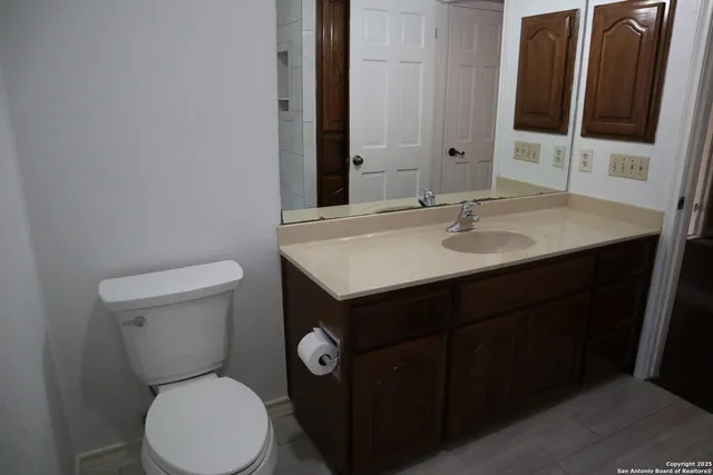 a bathroom with a toilet sink and mirror