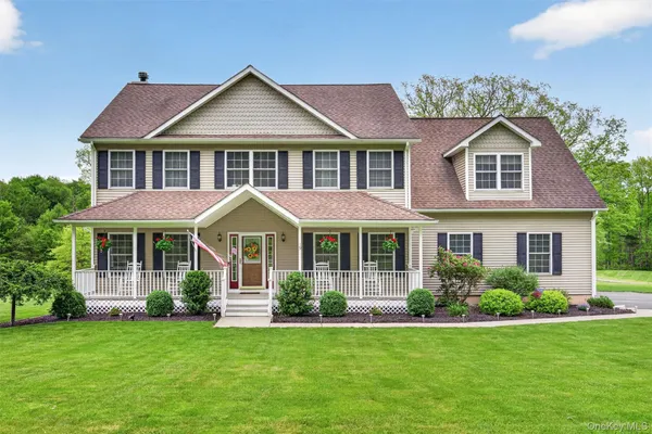 a front view of a house with a yard and green space
