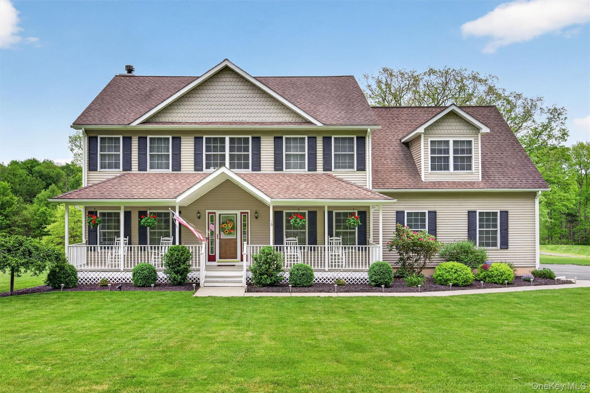 a front view of a house with a yard and green space