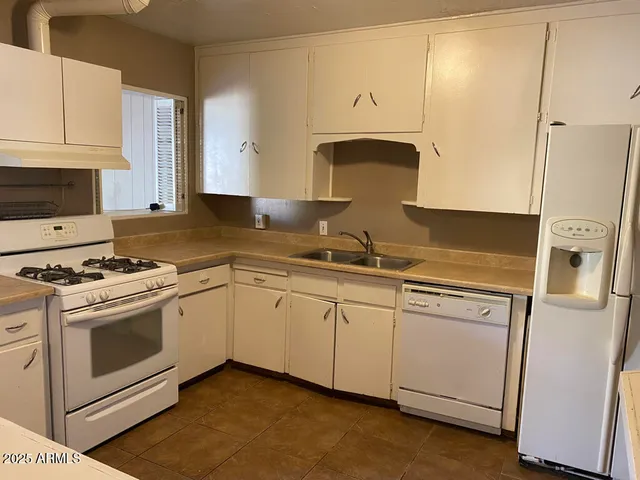a kitchen with granite countertop cabinets stainless steel appliances and a sink