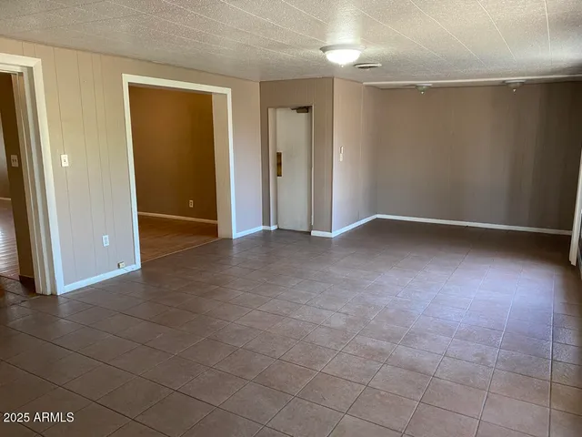 an empty room with wooden floor and mirror