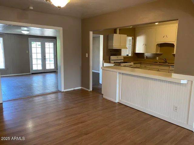 a large kitchen with stainless steel appliances granite countertop a stove and a wooden floors