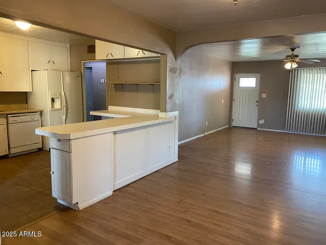 a view of a kitchen with wooden floor and a sink