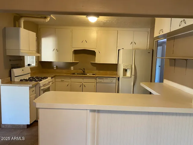 a kitchen with a sink a refrigerator and a stove