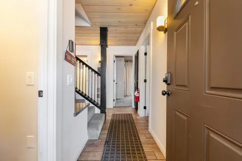 a view of a hallway with wooden floor and staircase