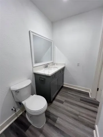 a bathroom with a granite countertop toilet and a sink