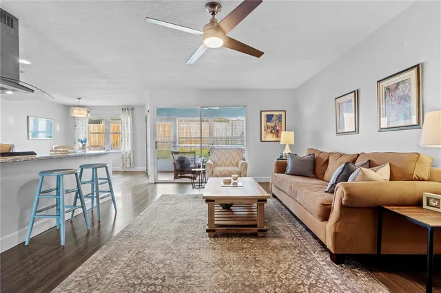 a kitchen with stainless steel appliances granite countertop a dining table chairs stove refrigerator and cabinets