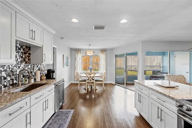a kitchen with granite countertop white cabinets and white appliances