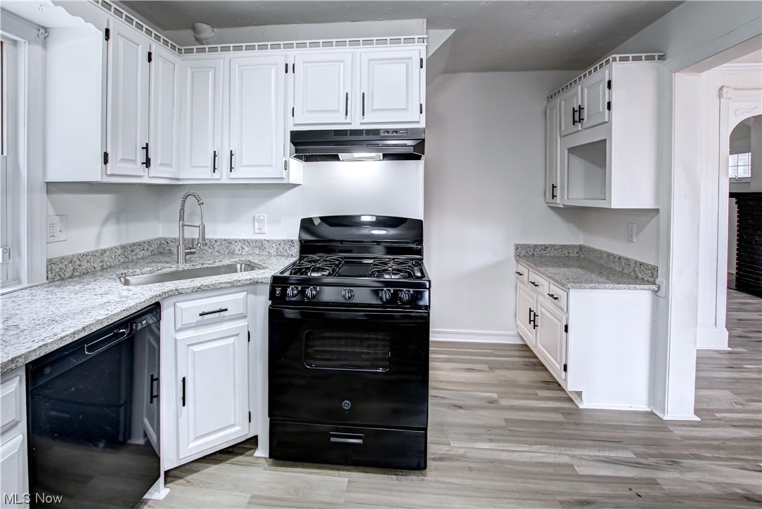 4764 Rockwood Road Cleveland, OH 44125 - Photo 5 of 35 Kitchen with sink, white cabinets, black appliances, range hood, and light wood-type flooring