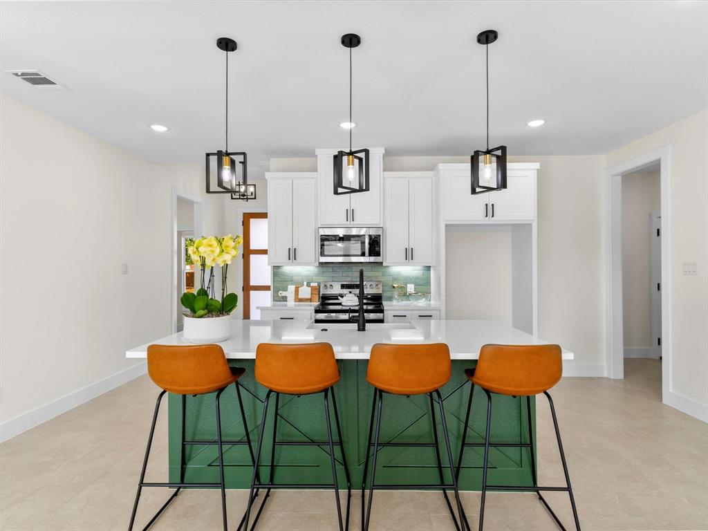 1623 County Road 4764 Boyd, TX 76023 - Photo 4 of 29 a kitchen with stainless steel appliances kitchen island granite countertop a table chairs and white cabinets