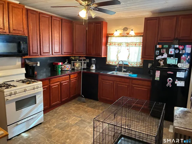 a kitchen with stainless steel appliances granite countertop a stove a sink dishwasher and a microwave oven with cabinets