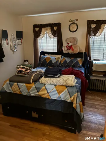 a bedroom with a bed and wooden floor