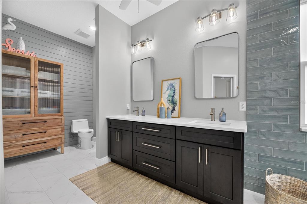5721 Sea Turtle Place Apollo Beach, FL 33572 - Photo 48 of 80 a spacious bathroom with a double vanity sink a large mirror and a toilet